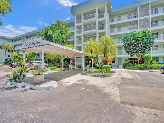 Front view of a multi-story residential building with a covered entrance.