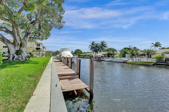 View of a canal with boats docked beside residential houses.