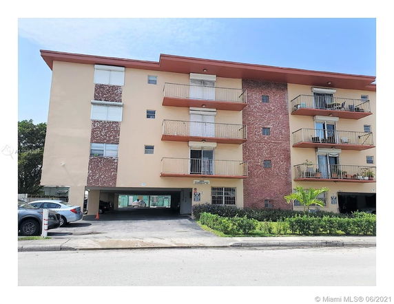 Front view of a multi-story apartment building with balconies.