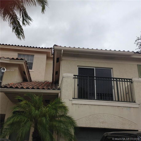 Front view of a house with a balcony and tile roof.
