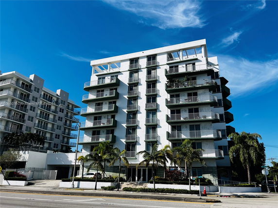 Front view of a multi-story apartment building with balconies.