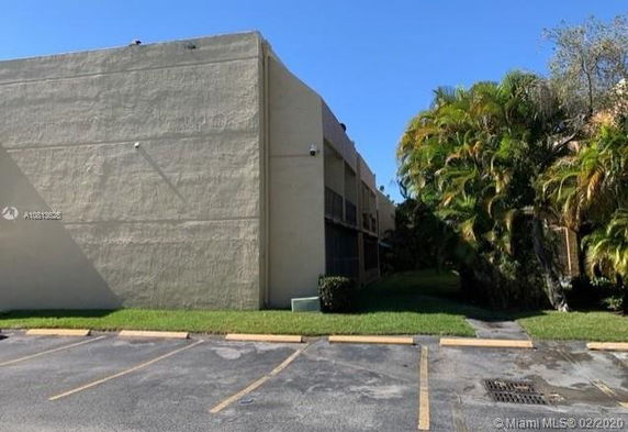 Outdoor parking area next to a building with a plain exterior wall.