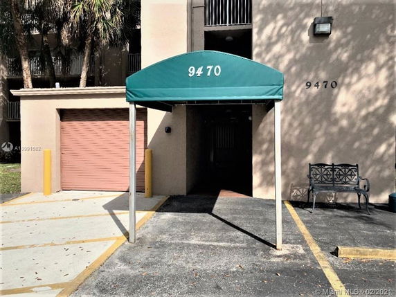 Entrance with a green canopy and a building facade showing the number 9470.