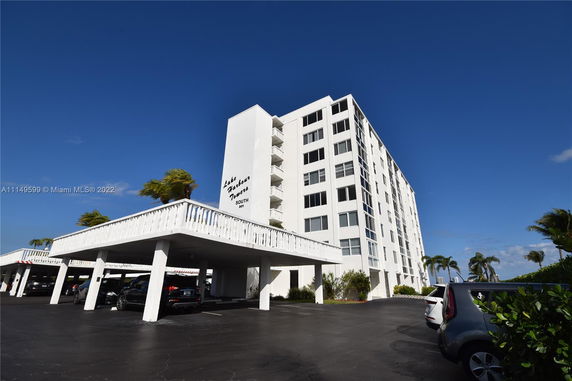 Front view of a multi-story residential building with a parking area.