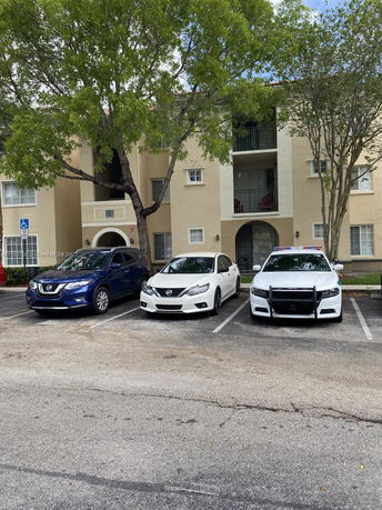 Outdoor parking area in front of a multi-story residential building.