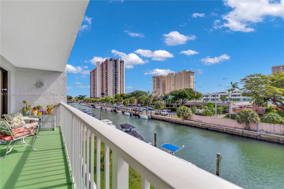 View from the balcony overlooking a canal with boats and tall buildings.