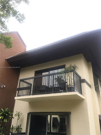 Front view of a two-story house with a balcony.