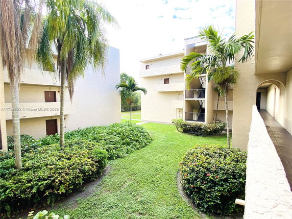View of a residential complex with three-story buildings and landscaped gardens