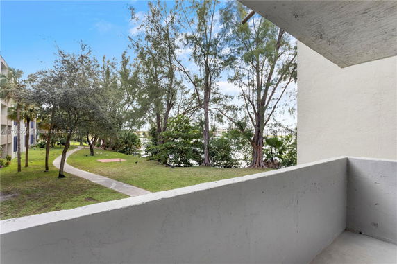 View from a balcony overlooking trees and a walkway.
