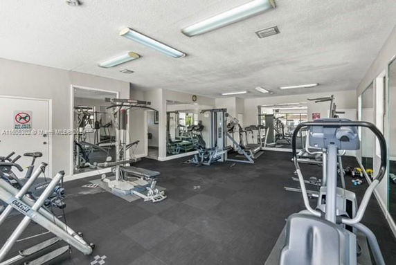 Indoor gym area with various exercise equipment and machines.