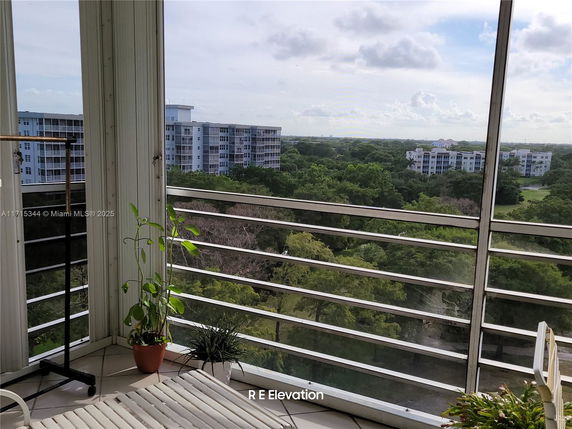 Panoramic view from a balcony overlooking residential buildings and greenery.