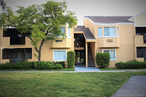 Front view of a two-story apartment building with an exterior staircase and balconies.