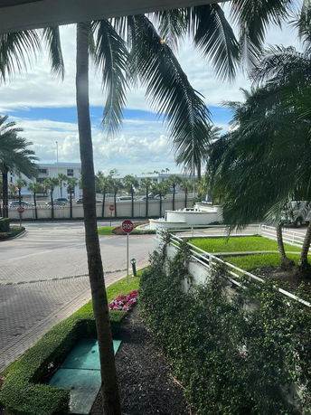 View of palm trees and stop sign with a building in the background