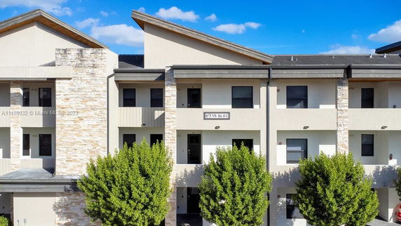 Front view of a multi-story apartment building with modern design and stone accents.
