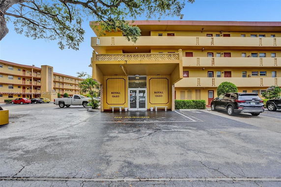 Front view of a multi-story residential building with parking area.