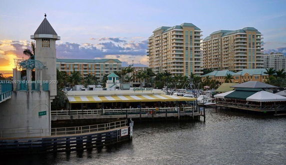 View of several multi-story buildings near a waterfront with a restaurant and a marina.