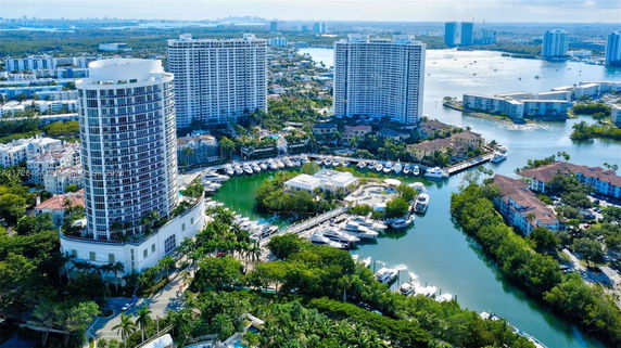 Aerial view of high-rise buildings with a marina and surrounding waterfront area.