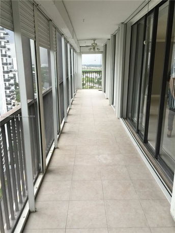 Long balcony with tiled floor and sliding glass doors.