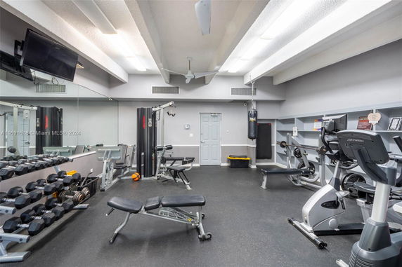 Interior view of a gym with exercise equipment and mirrors.
