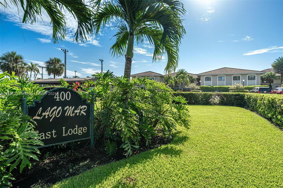View of a lodge building with tropical landscaping and a sign reading Lago Mar.
