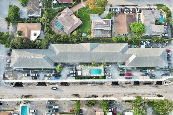 Aerial view of a residential complex with a swimming pool and parking area.