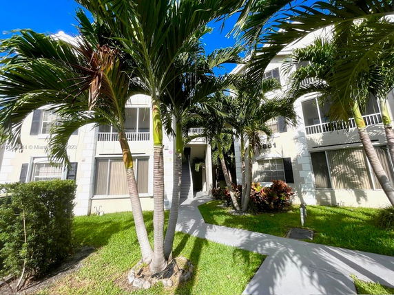 Front view of a multi-story residential building with covered entryway.