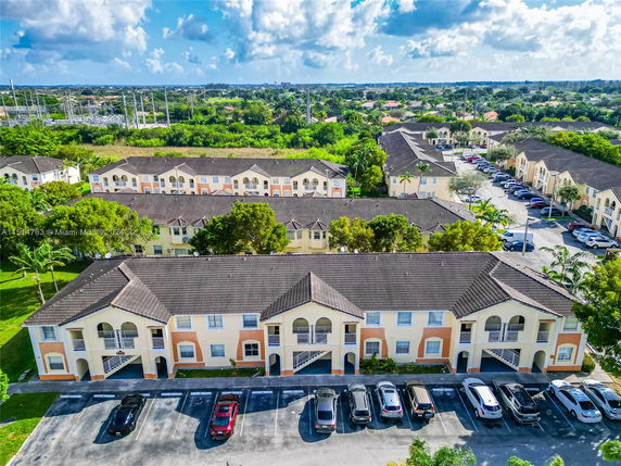 Aerial view of residential buildings with parking area in a suburban neighborhood.