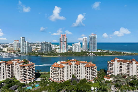 Wide view of buildings near a water body with other high-rise structures in the background.