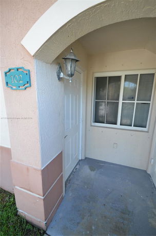 Front entryway of a house with an arched doorway.