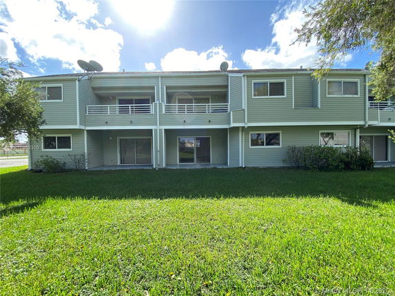 Front view of a two-story building with balconies and sliding doors.