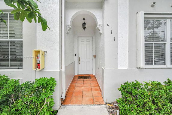 Front entrance of a building with a white door and archway.