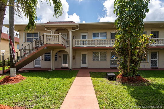 Front view of a two-story residential building with exterior stairs and balconies.
