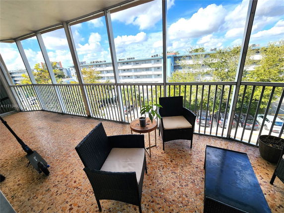 View from a balcony overlooking a residential area with buildings and trees.