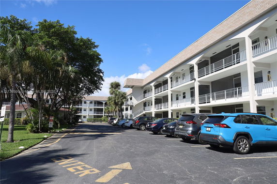 Outdoor parking area in front of a multi-story residential building.