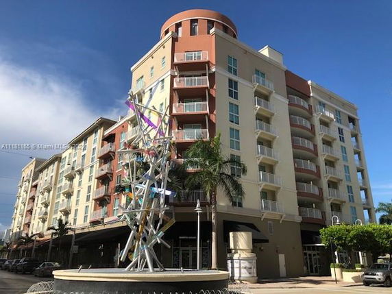 Front view of a multi-story residential building with multiple balconies.