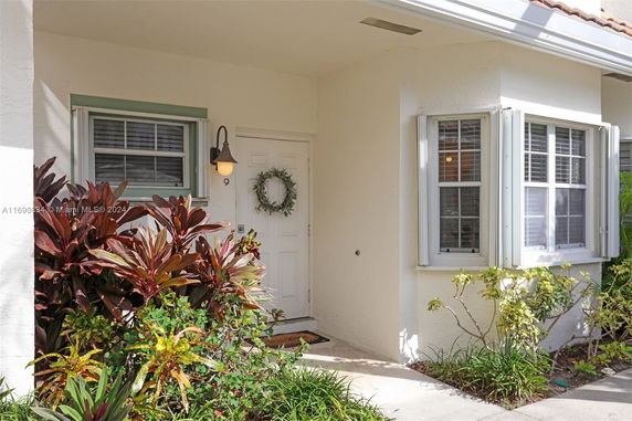 Front view of a house entrance with a white door and surrounding plants.