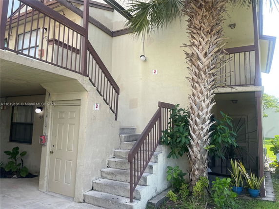 Front view of a two-story building with an exterior staircase.