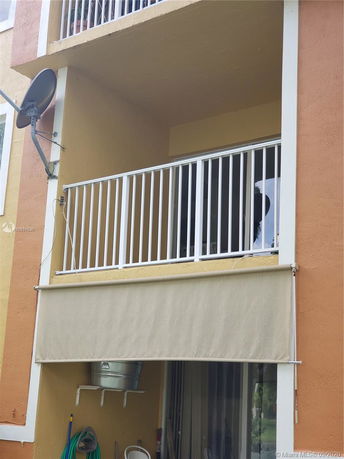 View of a building facade with balconies and satellite dish.