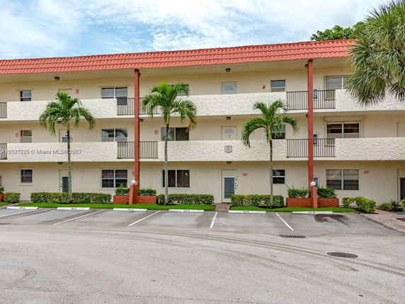 Front view of a three-story apartment building with a red-tiled roof.