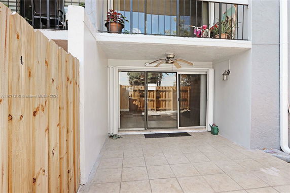 Outdoor patio area with tiled floor and sliding glass doors.
