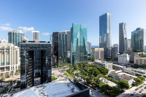 Panoramic view of a cityscape with multiple skyscrapers and a clear blue sky.