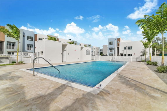 Outdoor view of a swimming pool surrounded by modern residential buildings.