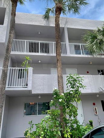Front view of a three-story building with balconies.