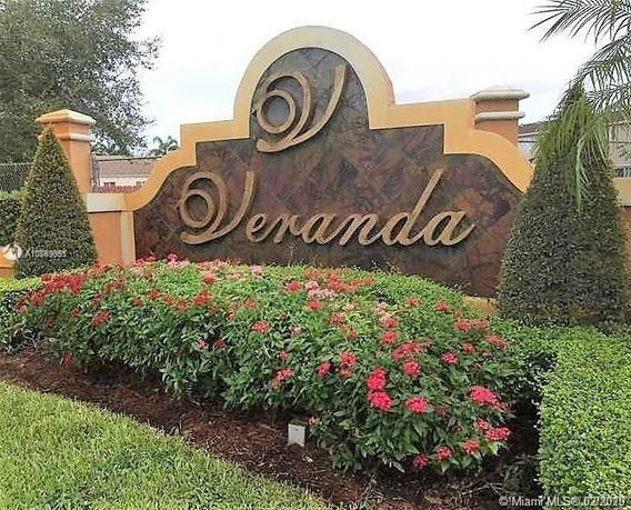 Entrance sign with decorative landscaping and foliage.