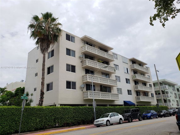 Front view of a multi-story apartment building with balconies.