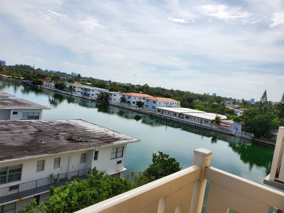 View of waterfront residential area with buildings and trees.