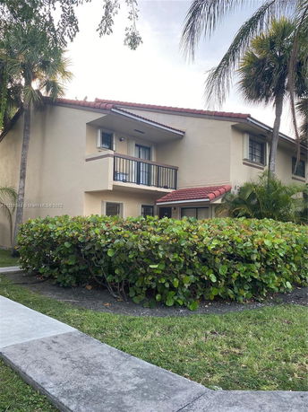 Front view of a two-story house with a small balcony and red-tiled roof.