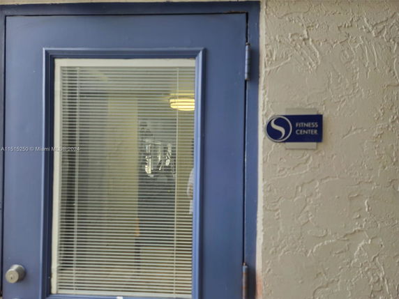 Entrance of a fitness center with a blue door and sign.