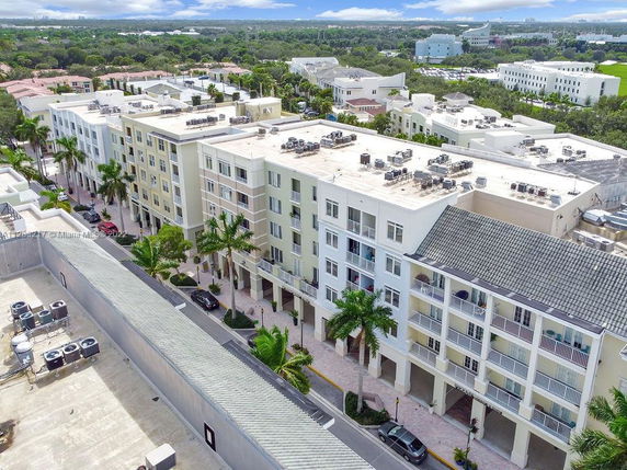 Aerial view of multi-story residential buildings with a flat rooftop and surrounding area.
