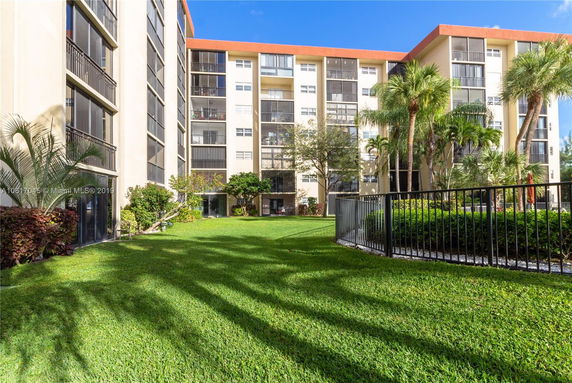 Front view of a multi-story building with balconies and large windows.